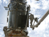 Astronaut on shuttle robotic arm working on the Hubble during a previous servicing mission