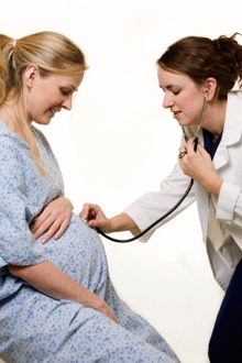 a photo of a pregnant woman being examined by a female doctor.