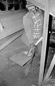 Worker using a shovel wearing a respirator