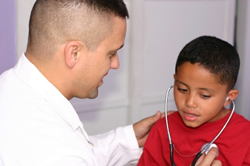 Doctor examining young boy.