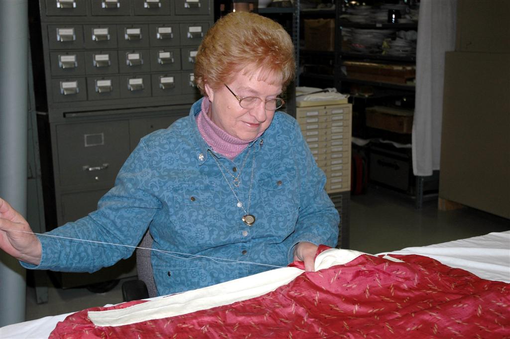 A staff member and volunteer working together in photo archives.