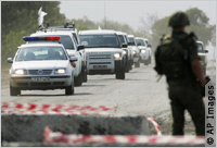 Line of vehicles approaching roadblock (AP Images)