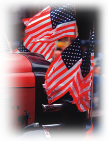 Image of a car with many US Flags waving