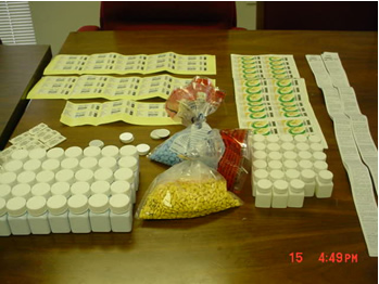 This picture shows counterfeit pills in plastic bags and the bottles and labels used to package the drugs. 