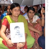 Sarmila Tripathi, 36, left, holds her missing husband's portrait, as she along with others stages a sit- in protest in Katmandu, Nepal (File)