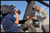 Sgt. Robert McNeil (center) of the 1st Battalion, 111th Aviation Regiment, talks with television host Chris Grundy (right) 