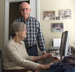 Margaret and Vernon Huffer at their Portland, Oregon, home, where researchers have installed motion sensors. One of the sensors can be seen between the photos on the wall.