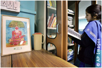 girl at bookshelf near drawing of bearded man (AP Images)