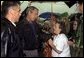 Listening to the story of how a tornado swept through their town, President George W. Bush meets one-on-one with residents during his walking tour of Pierce City, Mo., Tuesday, May 13, 2003.  White House photo by Susan Sterner