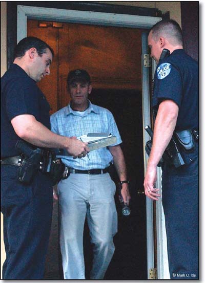 Photograph: Two police officers at the front door of a residence talking to a citizen