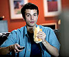 Photo of boy eating sandwich while watching TV