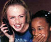 photo of 2 young girls laughing, one talking on phone