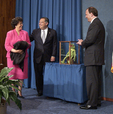 Secretary Abraham and Deputy Secretary Kyle McSlarrow (right) accept a symbolic Kermit the Frog from Kay Coles James, Director, Office of Personnel Management, on behalf of DOE and its employees for their eforts and hard work in puting the PMA initiatives into practice.