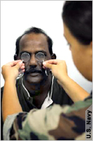 Spectacles held up in front of man’s eyes (U.S. Navy)