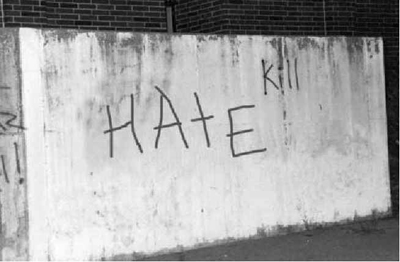 Photograph of a wall painted with "hate" graffiti
