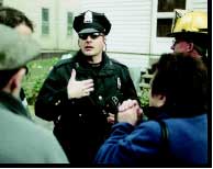 Photograph of police officer speaking to a group of citizens