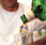 Photograph of alcohol pouring from a bottle into a glass