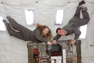 Two university students with an experiment onboard the reduced gravity aircraft.