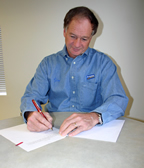 Photo of Jim Perdue signing agreement.