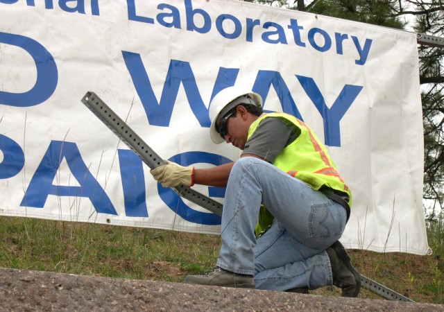 Duane Pacheco of KSL Services assembles the steel sign posts.