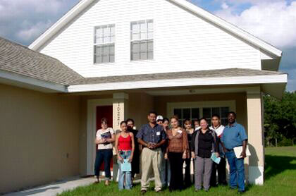 Picture of Jesse Ornales and Hope Figueroa standing proudly with future homeowners who attended a Focus Group Workshop sponsored by Homes for Hillsborough.