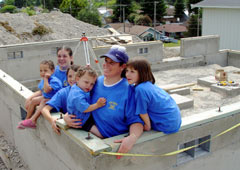 Karin Escobar and her five children, ages 2-14, in the foundation of their new home.