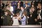 First Lady Laura Bush and Army Staff Sgt Norbert Lara, foreground left, injured in action, look on as William Norwood, whose 25-year-old son, Marine Sgt. Byron Norwood, was killed in action in Iraq, reaches out to Marine Staff Sgt. John Manuel Martinez while the dead Marine's mother, Janet Norwood, embraces Safia Taleb al-Suhail, leader of the Iraqi Womens Political Council. White House photo by Eric Draper