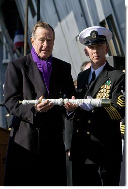 Former President George H.W. Bush presents a long glass to the First Officer of the Deck to set the first watch Saturday, Jan. 10, 2009, during commissioning ceremonies for the USS George H.W. Bush (CVN 77) aircraft carrier in Norfolk, Va. White House photo by David Bohrer