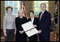 President George W. Bush and Mrs. Bush present the Preserve America award for heritage tourism to Dr. Bonnie McEwan, Executive Director, Mission San Luis of Tallahassee, Fla., left, and Mrs. Columba Bush, the First Lady of Florida, in the Oval Office Monday, May 1, 2006. White House photo by Eric Draper