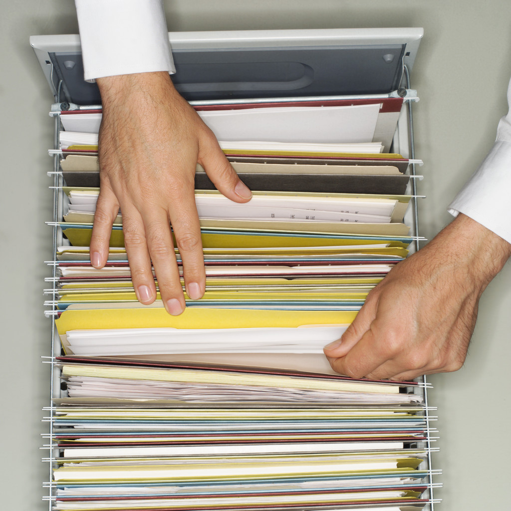person sorting paper files