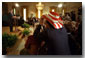 President George W. Bush addresses the audience in the East Room as actor Rob Schneider, decked out in a patriotic cowboy hat, takes a photograph Nov. 2. White House photo by Eric Draper.