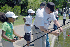 Photograph: Volunteer helps get pond algae off happy angler's hook.