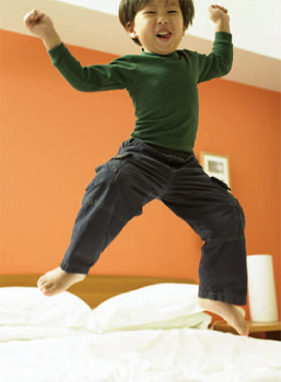 boy jumping on a bed