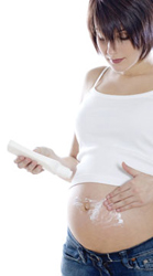 pregnant woman applying lotion