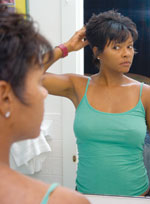 African-American woman looking in mirror