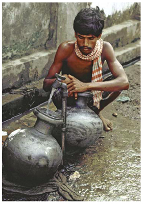 man collecting water from a well