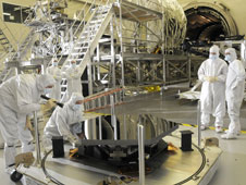 Engineers from Ball Aerospace inspect the first James Webb Space Telescope mirror segment upon its arrival at Marshall Space Flight Center, Huntsville, Al. for cryogenic testing.