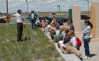 Picture of a Trails Center employee talking to Oregon Trail Elementary students and teachers.