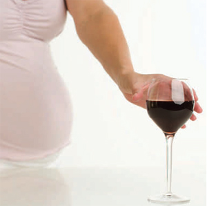 pregnant woman reaching for glass of wine