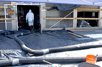 Slidell, La., September 28, 2005 - An environmental cleanup firm's employee enters a building to continue the cleaning up process necessary to remove hundreds of bags of decomposing fertilizers and animal feed that are now emitting toxic ammonia gas. The EPA is tasked by FEMA to oversee all Hurricane Katrina spills and contamination cleanups . Win Henderson/FEMA
