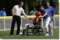 Former Major League pitcher Jim Abbott congratulates a player from the Challenger Phillies from Middletown, Delaware at Tee Ball on the South Lawn at the White House on Sunday July 11, 2004.  White House photo by Paul Morse