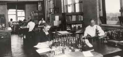 picture of Burton Howard and unknown woman in old-fashioned laboratory.