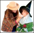 (Photo of a woman applying halloween makeup to a child)