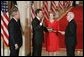 President George W. Bush watches Thursday, Sept. 29, 2005 in the East Room of the White House in Washington, as Judge John G. Roberts is sworn-in as the 17th Chief Justice of the United States by Associated Supreme Court Justice John Paul Stevens. Judge Roberts' wife Jane is seen holding the Bible. White House photo by Paul Morse