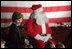 Laura Bush talks with a group of children as she visits the Naval and Marine Corps Reserve Center in Gulfport, Miss., Monday, Dec. 12, 2005, where she showed them White House holiday video featuring the Bush's dogs "Barney and Miss Beazley."