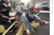 Palestinians transport wounded people in a car outside Gaza City’s al-Shifa hospital, 15 on Jan 2009