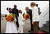 President George W. Bush and Mrs. Laura Bush are greeted by children with flowers on their arrival Tuesday, Feb. 19, 2008 to Kigali International Airport in Kigali, Rwanda.