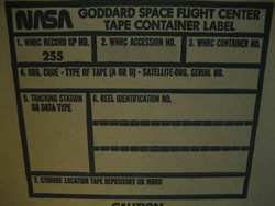 Pictured is the side of a blank Tape Container box. Boxes like these likely contain the tapes in question and have tracking information filled out on the label from when they were initially sent to the National Records Center. Each box can contain up to five data tapes.