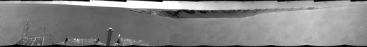 This black-and-white image shows a 360-degree panorama of 'Victoria Crater' straight ahead. To the left, Opportunity's wheel tracks extend toward the rover across the Martian plains. To the right is uncharted terrain.