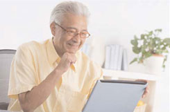 Image of elderly man looking at his computer screen.